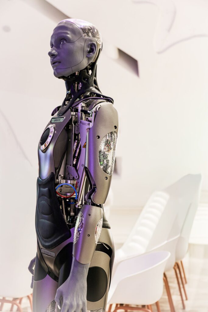 Futuristic humanoid robot in a modern conference environment representing AGI scenarios and future intelligence systems.